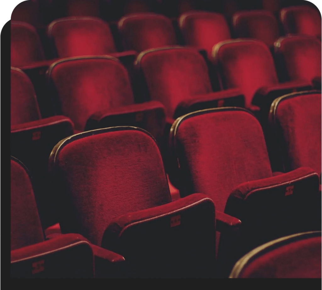 A row of red seats in an auditorium.